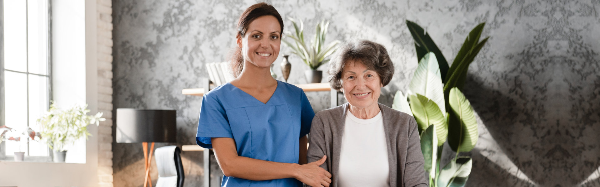 nurse and elderly woman looking at the camera